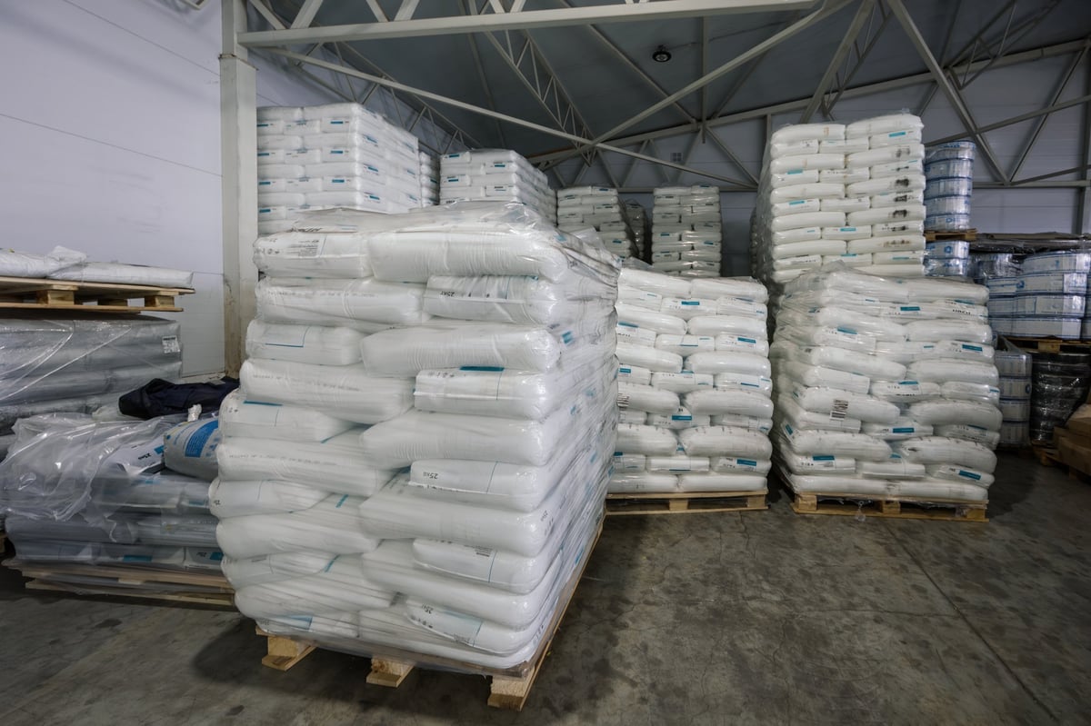 White polyethylene bags with factory products in warehouse.