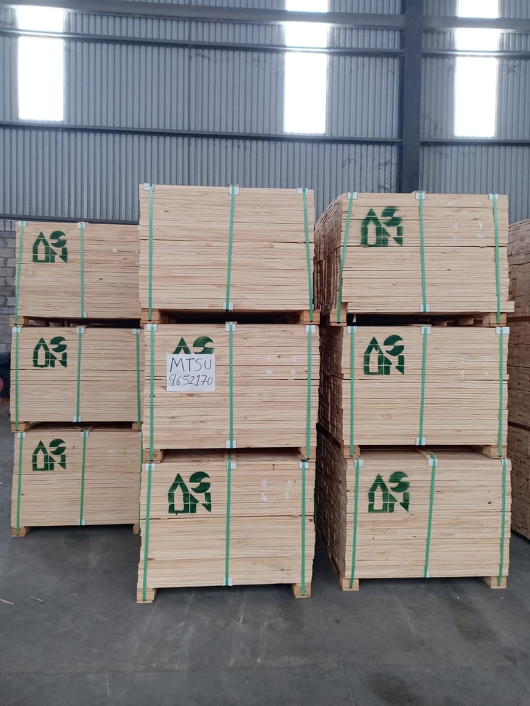 Wooden shipping crates stacked in warehouse with green straps and building markings
